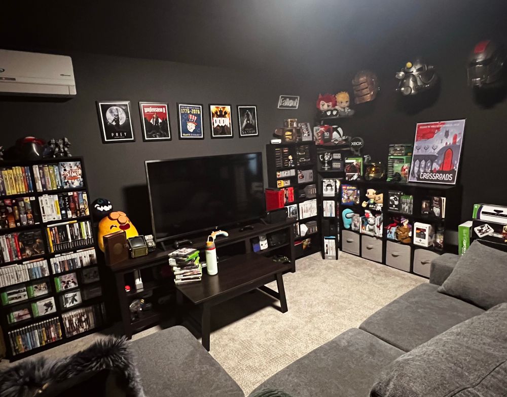 Mo’s gaming room filled with various consoles, physical game discs, and merch.