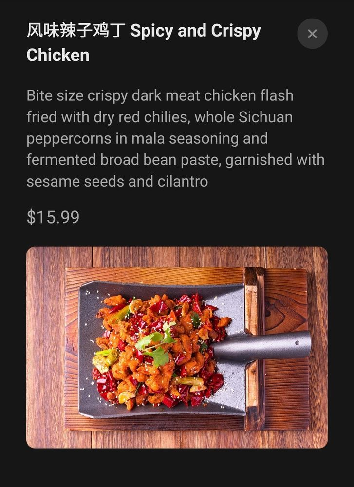 Screenshot of Spicy and Crispy Chicken from the Houston restaurant Mala Sichuan. "Bite size crispy dark meat chicken flash fried with dry red chilis, whole Sichuan peppercorns in Mala seasoning and fermented broad bran paste, garnished with sesame seeds and cilantro". It is served on the head of a shovel for some reason.