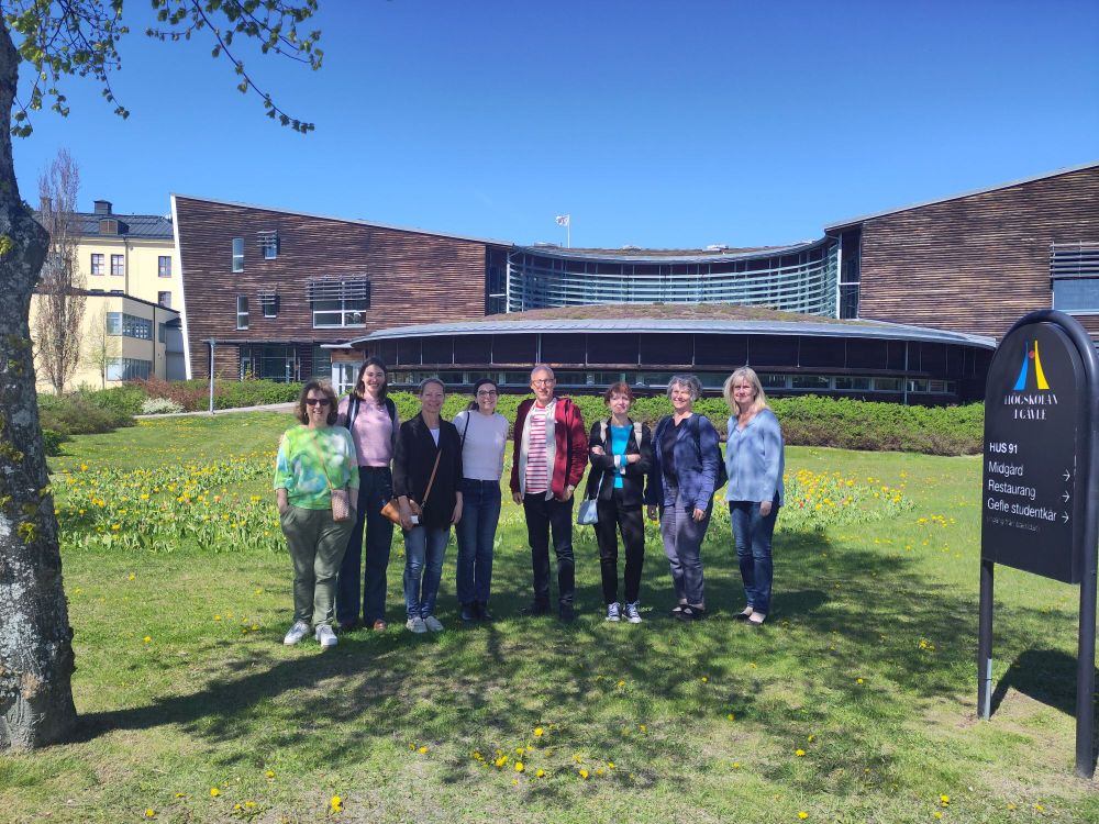 8 people standing in front of a building 