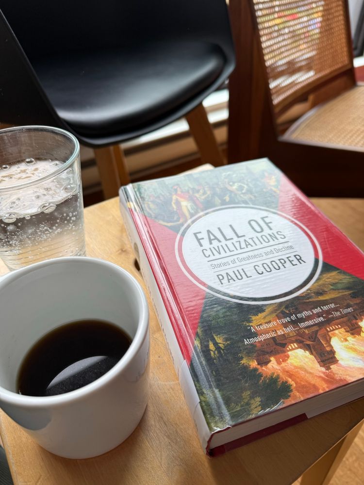 Book about fall of civilizations, a coffee mud and a glass of water