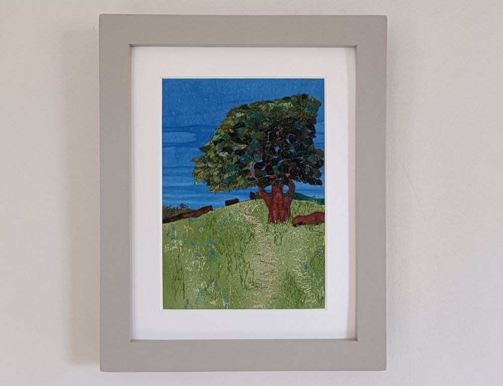 fabric picture showing tree with summer foliage on hillside, detail shown with machine embroidery 