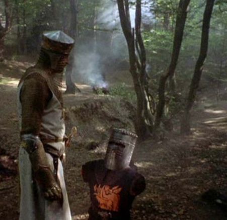 Monty pythons holy grail - the black knight has no arms or legs as King Arthur stands over him in a forest
