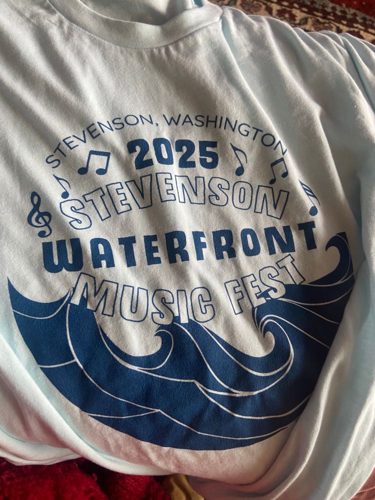 light blue tee shirt with a logo for the 2025 Stevenson waterfront music fest in Stevenson, Washington 