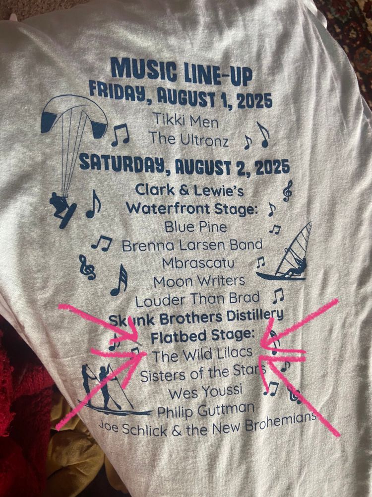 Back of shirt: 

MUSIG LINE UP
FRIDAY, AUGUST 1, 2025
Tikki Men
The Ultronz
SATURDAY, AUGUST 2, 2025
Clark & Lewie's
Waterfront Stage: D
Blue Pine
JI Brenna Larsen Band
&
Mbrascatu
Moon Writers
Louder Than Brad
Skunk Brothers Distillery
Flatbed Stage:
The Wild Lilacs
Sisters of the Star
Wes Youssi
Philip Guttman
Joe Schlick & the New Brohemians.

Pink arrows point to the wild lilacs