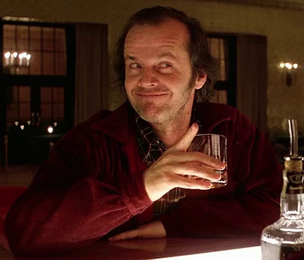 a man sitting at a bar with a bottle of jack daniels in front of him