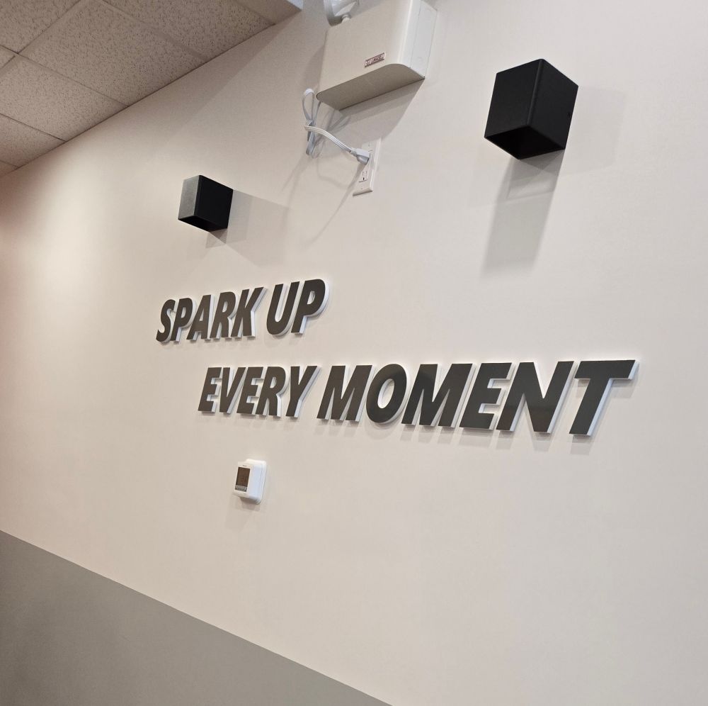 sign at a bubble tea shop that says spark up every moment 
