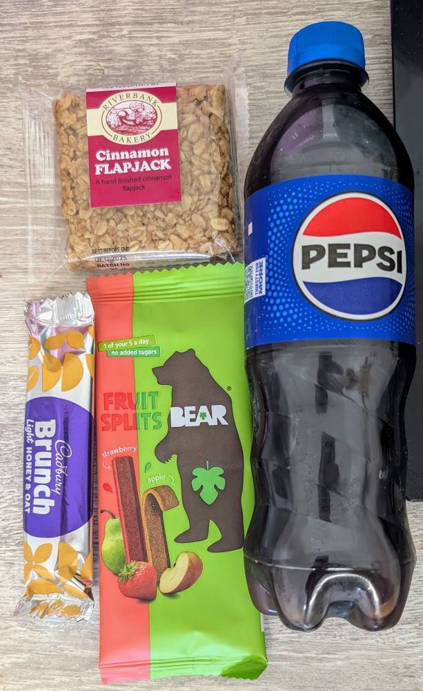 A bottle of Pepsi, a cinnamon flapjack, a Bear Fruit Splits snack and a Cadbury Brunch Light Honey & Oat bar
