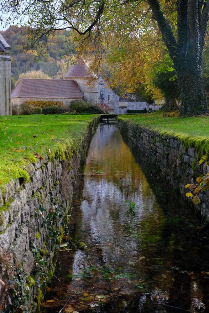 A canal is dug and walled, leading to a tower made of white stones