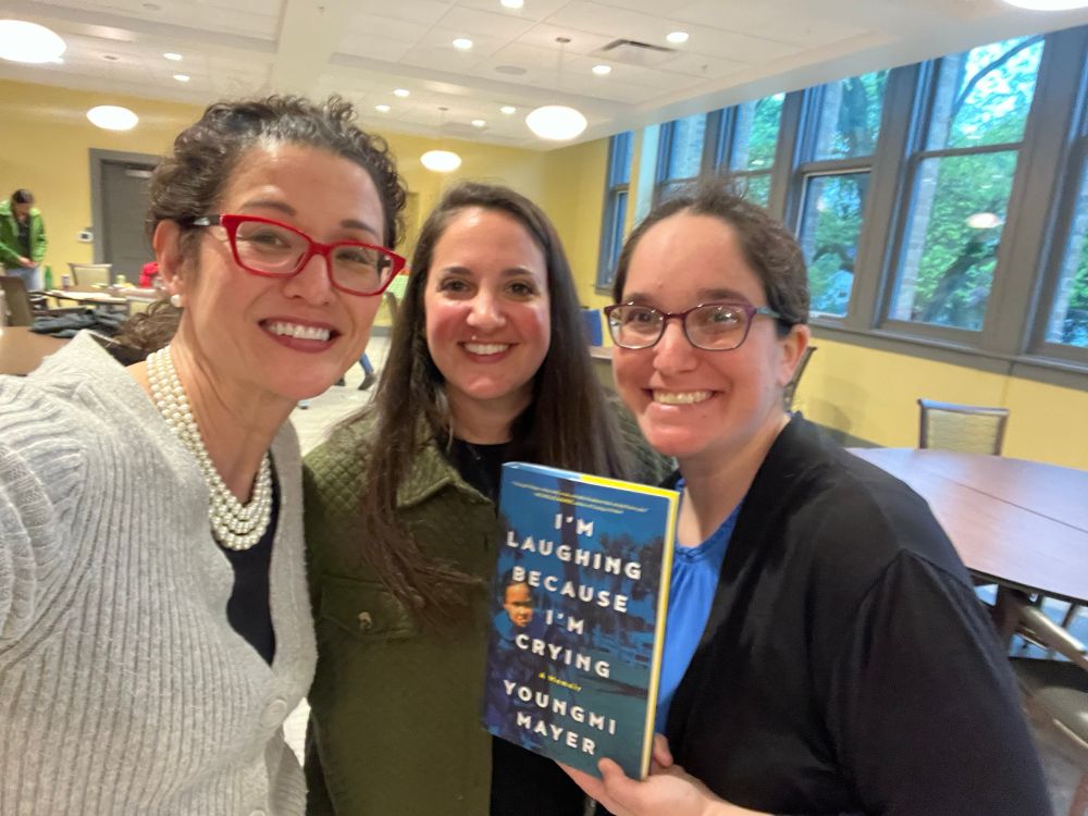 Three people one holding a book