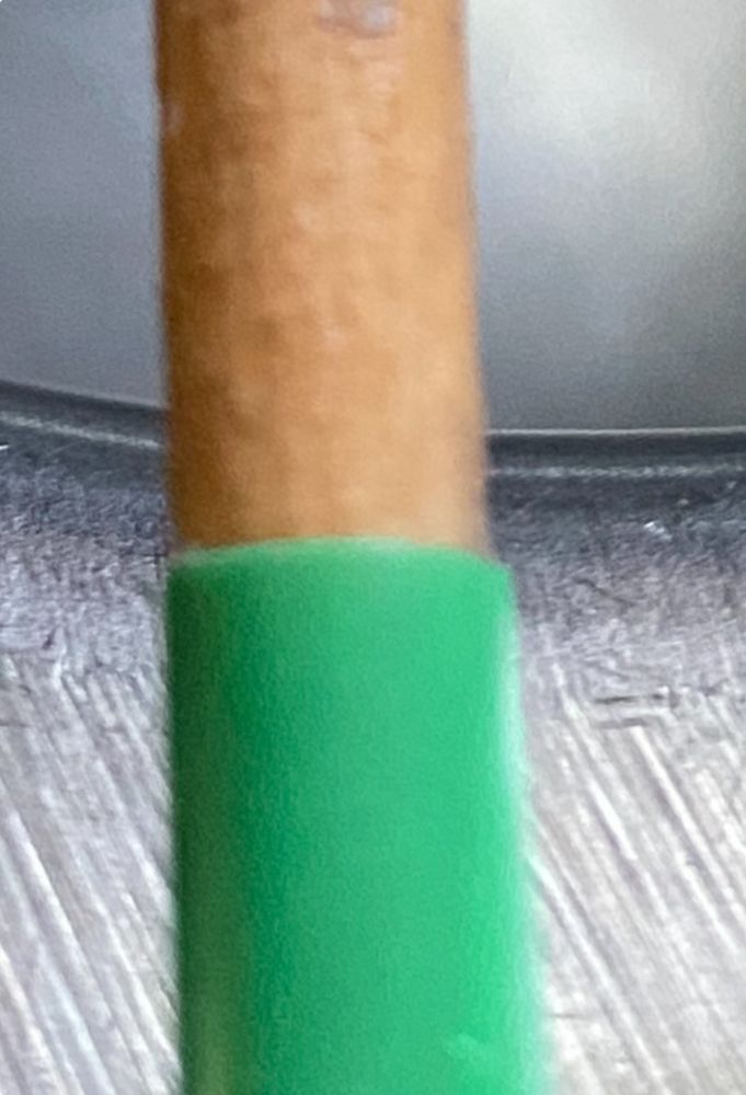 Green straw holding end of small paintbrush that was dropped in sink. Used straw to slide around brush handle- it worked.
