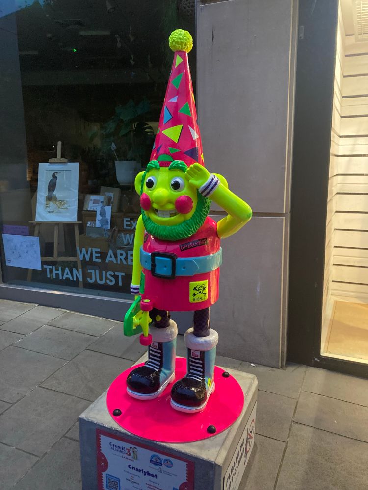 Norbot gnome statue in vivid neon pinks and yellows