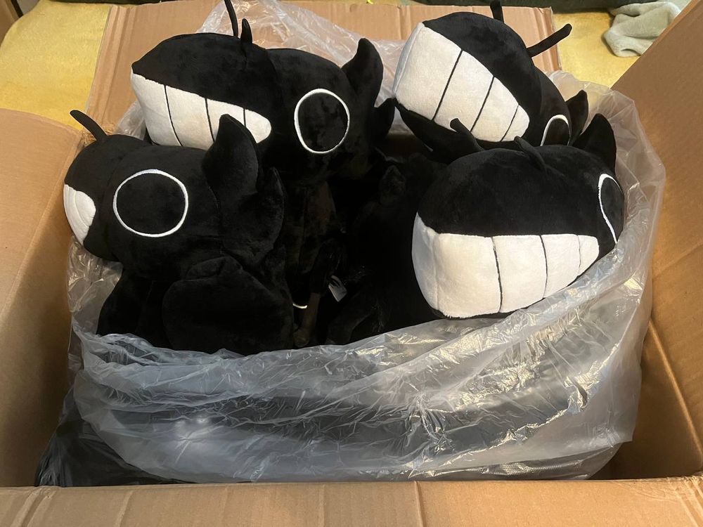 A picture of a box full of crow plushies with teeth called fishcrows.