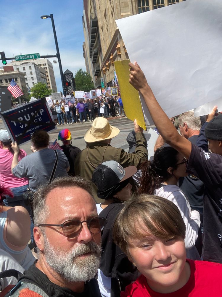 Man and son in crowd at No Kings Protest