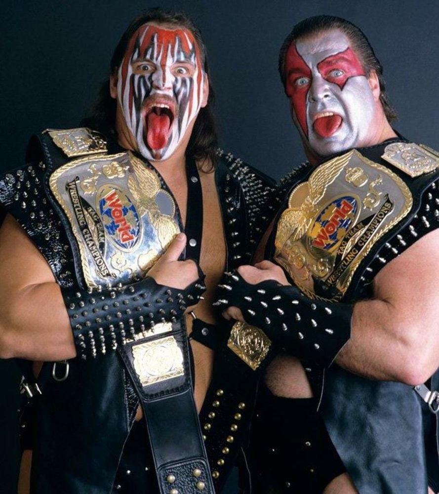 Smash (Barry Darsow) and Ax (Bill Eadie) of Demolition, holding the WWF Tag Team Championship belts