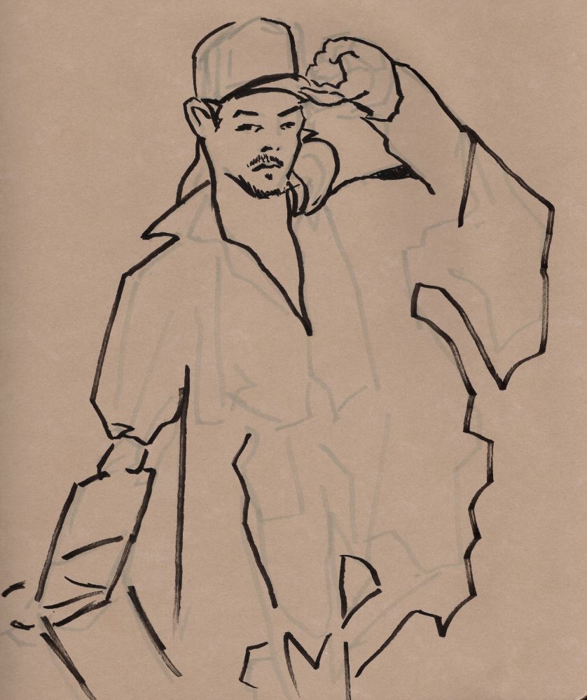 model Joseph wearing a baseball hat and draped in several coats leans on a chair
