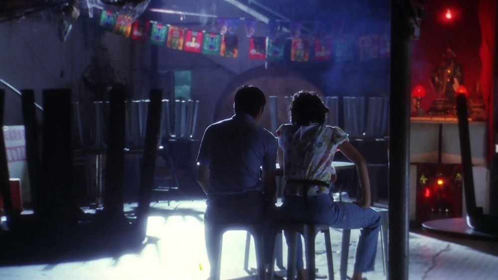 God of Cookery. Stephen Chow and Karen Mok sit at a table at night