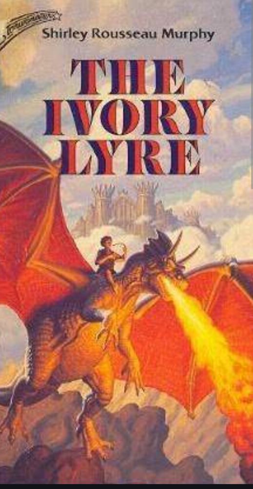 The cover for The Ivory Lyre by Shirley Rousseau Murphy showing someone astride a flying fire-breathing dragon's neck while playing a lyre. In the background there is a castle, clouds and rocky mountains. 