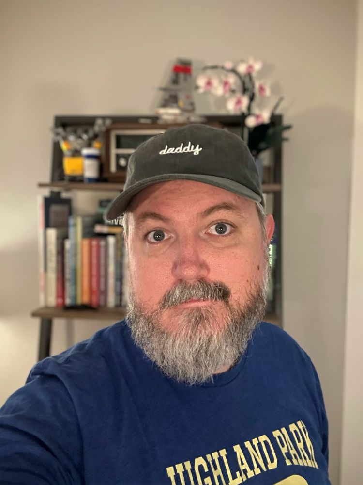 Me, a gray bearded daddy wearing a hat that says “daddy”