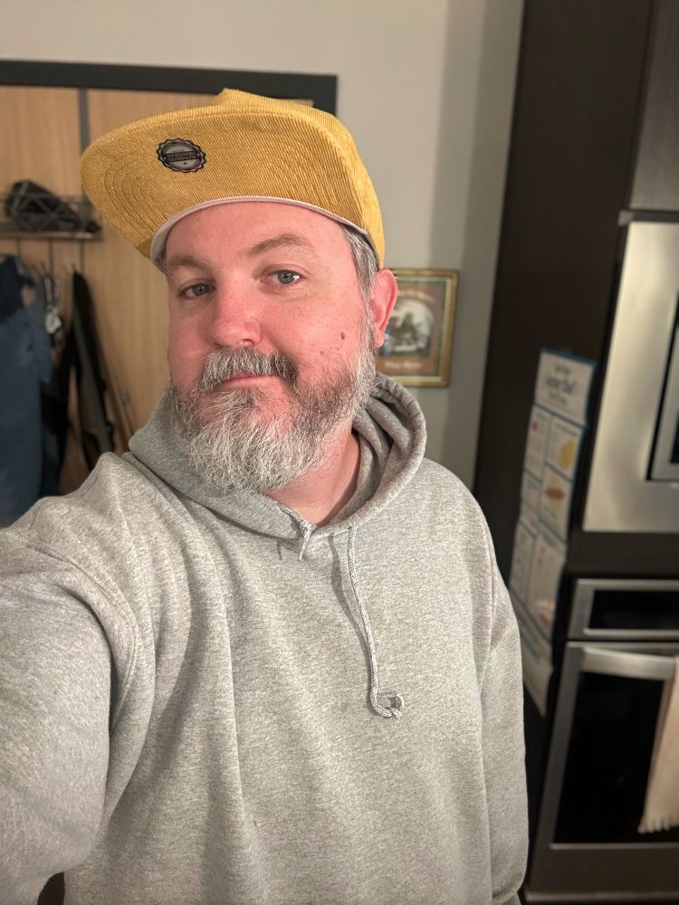 A selfie of me in a gray hoodie and tan hat