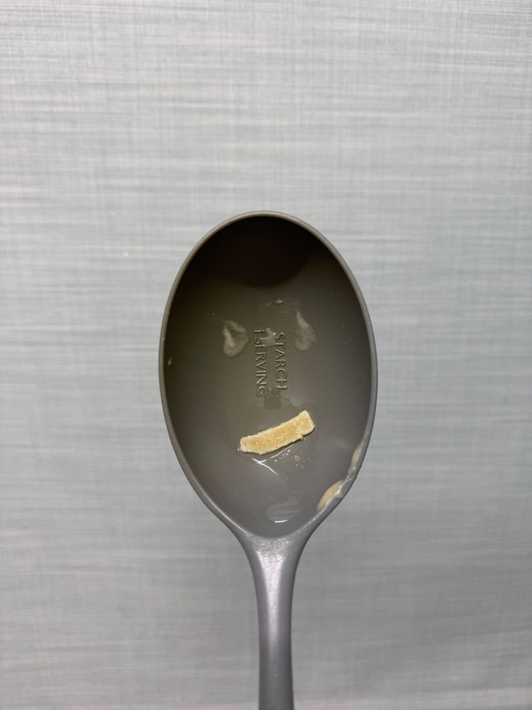 Passport photo of a ladle spoon with a face made of pasta. It has a cheeky tagliatelle smile.
