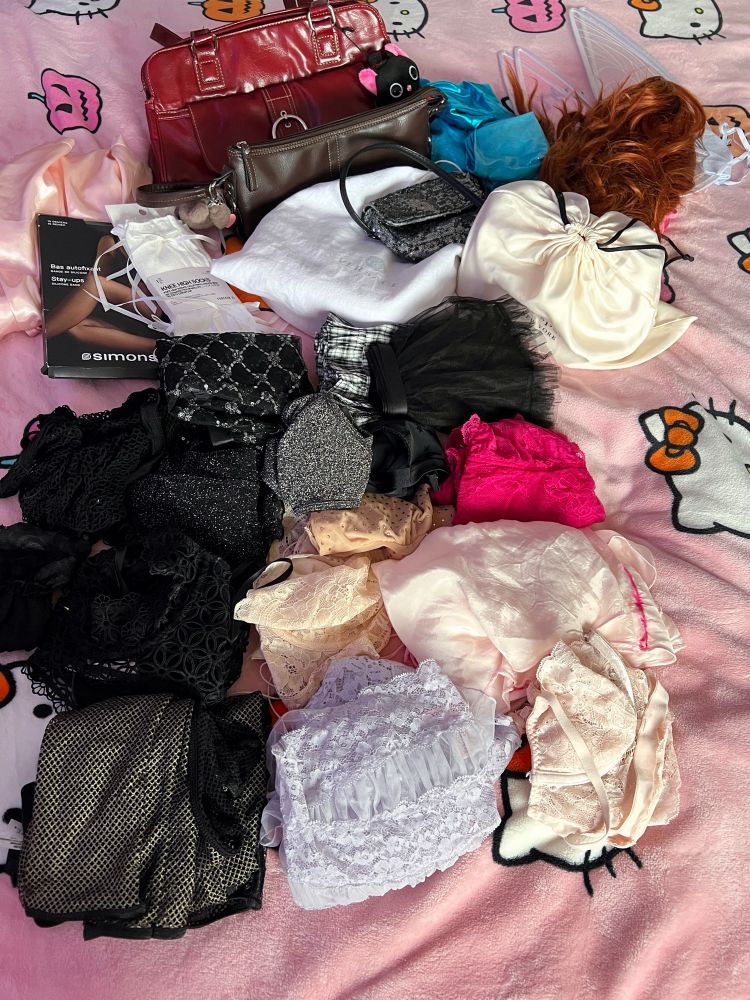 Assorted lingerie, stockings, purses, and accessories on a pink hello kitty blanket. 