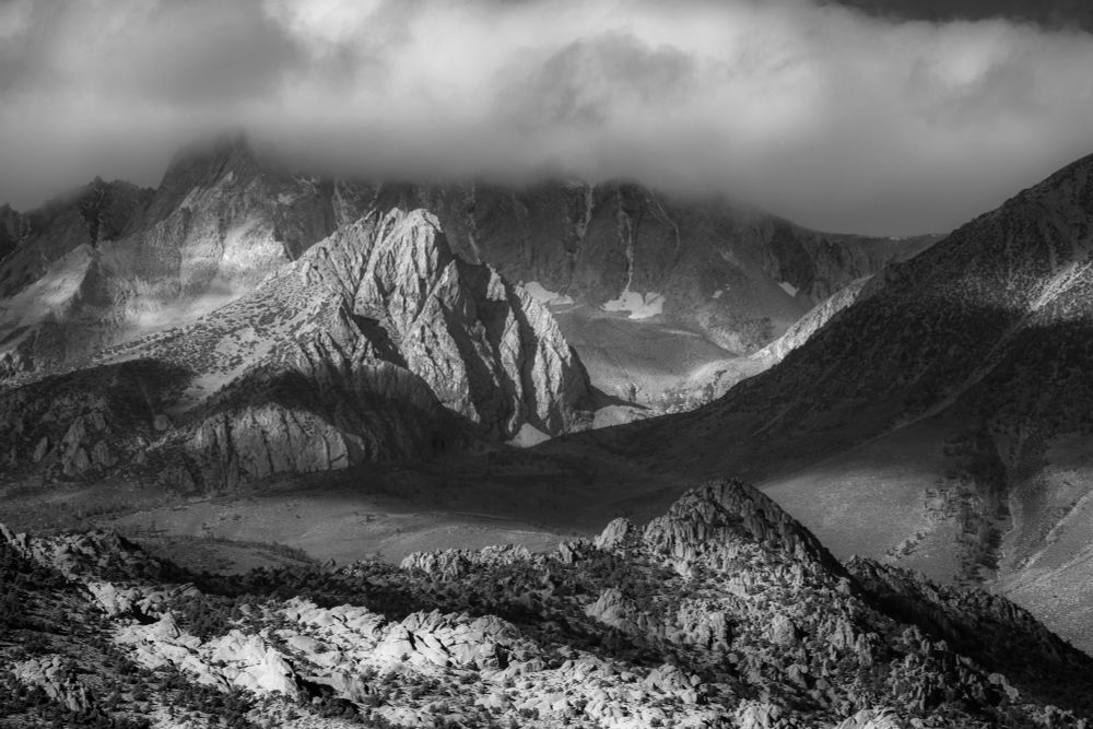 A scene from the Eastern Sierra of California, looking upslope from Buttermilk Country toward the crest. Passing clouds create highlights and shadows on the scene.