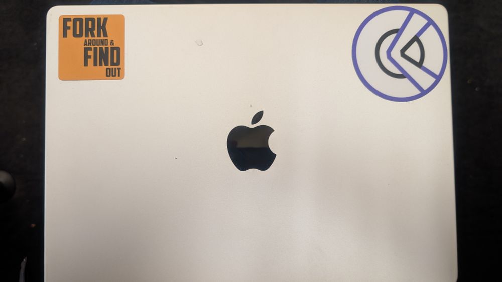 A laptop with a "Fork Around & Find Out" sticker. 
