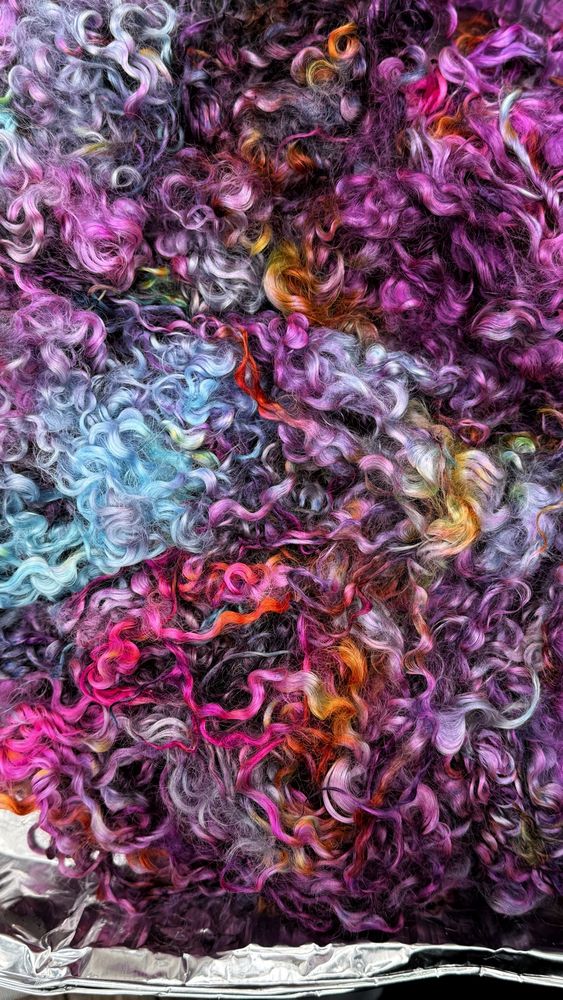Teeswater x Leicester long locks dyed in shades of pink, purple, brown, and orange, drying 