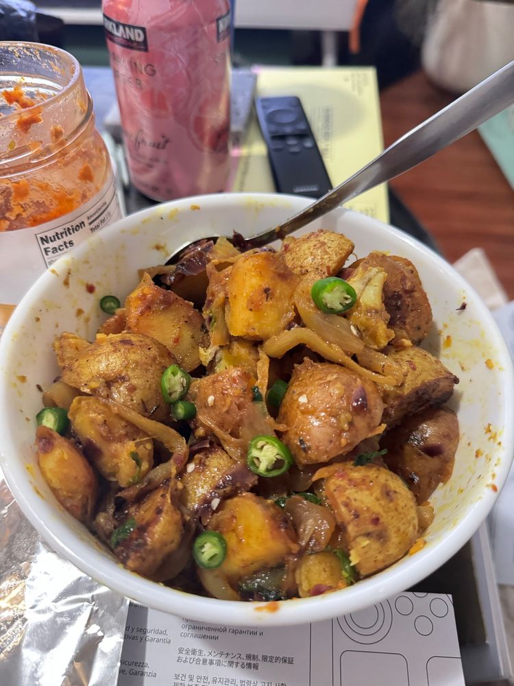 Curry potato dish topped with green chillies. 