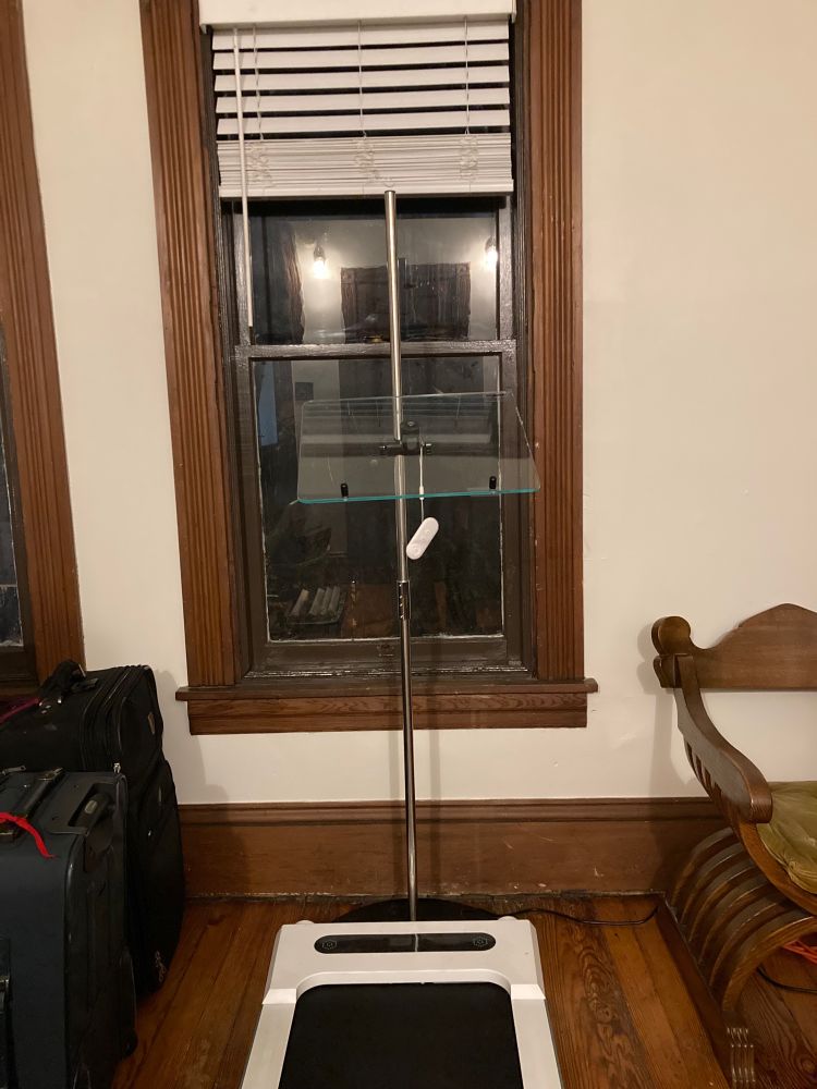 A room with a window, a treadmill, and a walking desk.