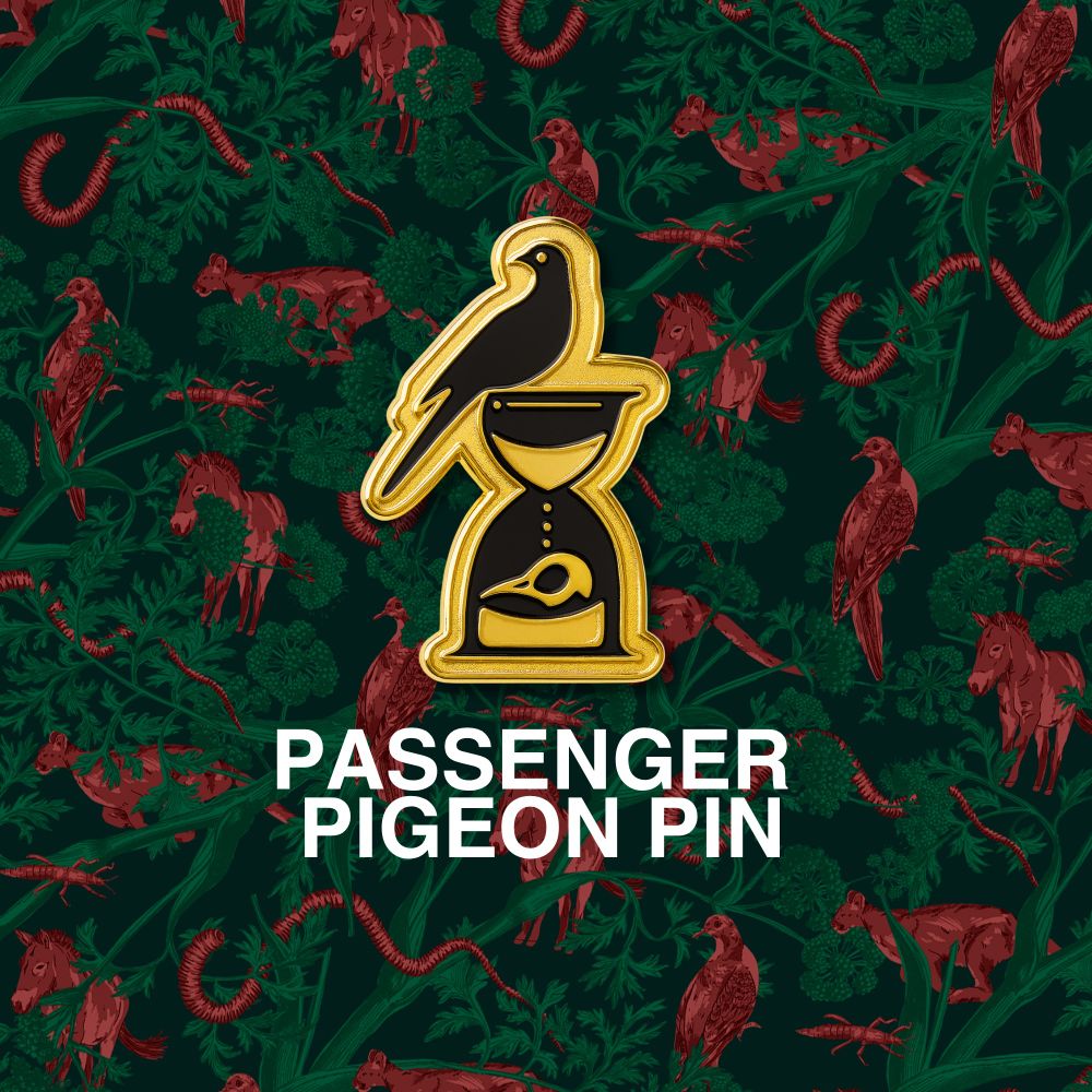 a mockup of a golden pin featuring a passenger pigeon on top of an hour glass with a bird skull in the bottom. 