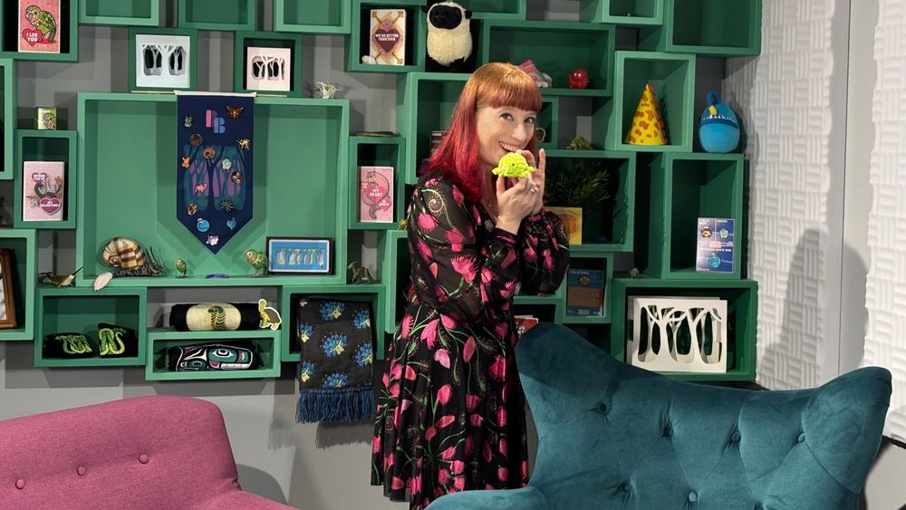 Sarah Suta holds up a tiny crocheted frog she made on the set of the new Bizarre Beasts ranking show!