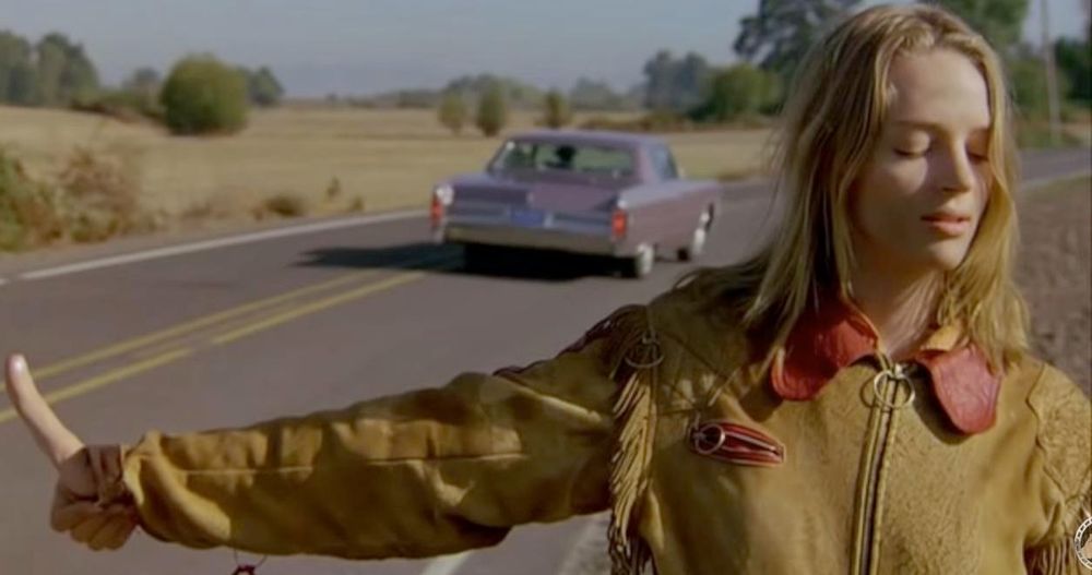A still from "Even Cowgirls Get The Blues" showing Uma Thurman's character Sissy hitchhiking