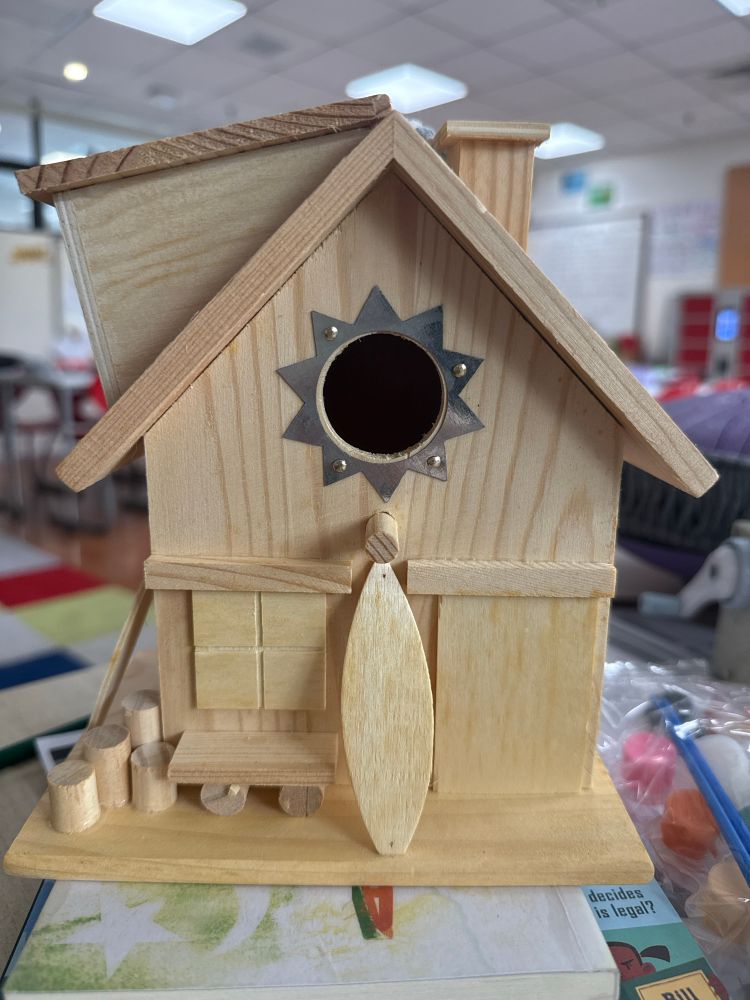 A wooden, unpainted birdhouse