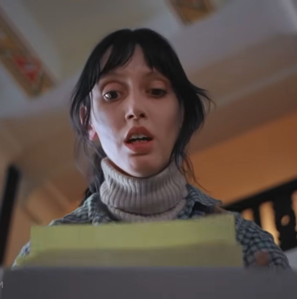 Shelly Duvall looking distressed as she discovers the "All work and no play" writings in The Shining
