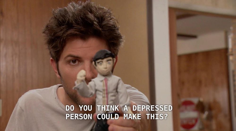 Adam Scott from Parks and Rec holding up a cheap sculpture saying "do you think a depressed person could make this?"