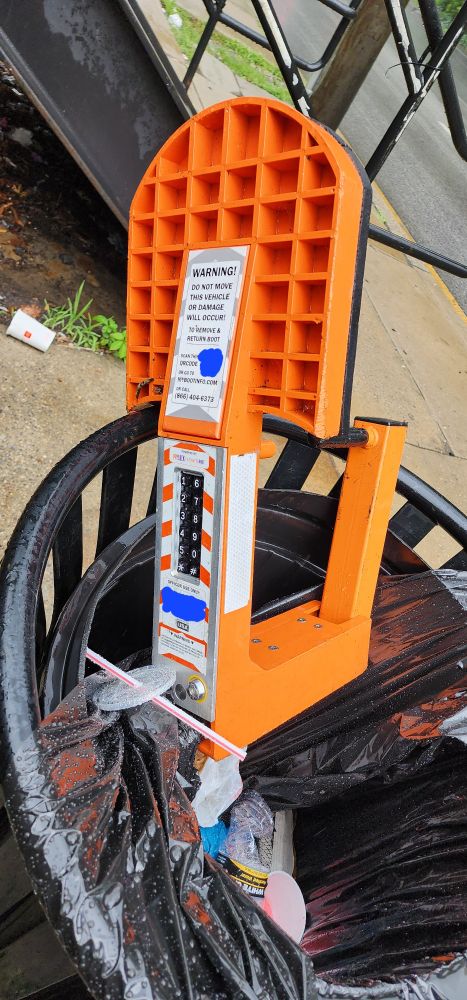 A parking boot in a trash can