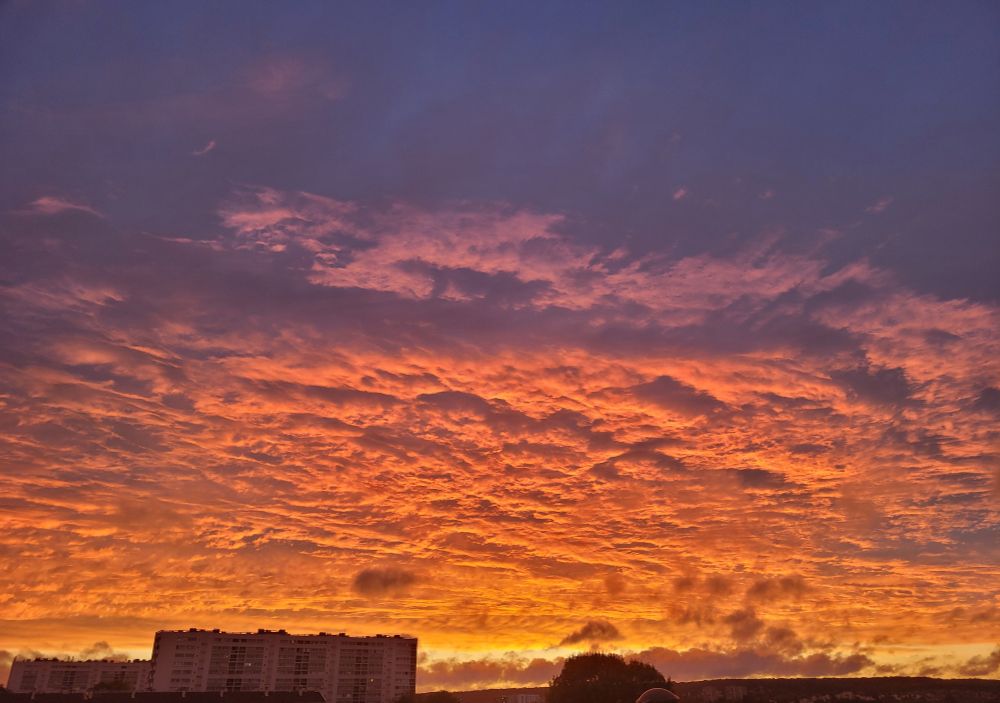 Ciel de coucher de soleil sur une mer de nuages, colorés de rose et orange 