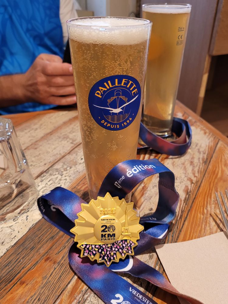 Médaille du 20km de Paris posé contre un verre de bière. 