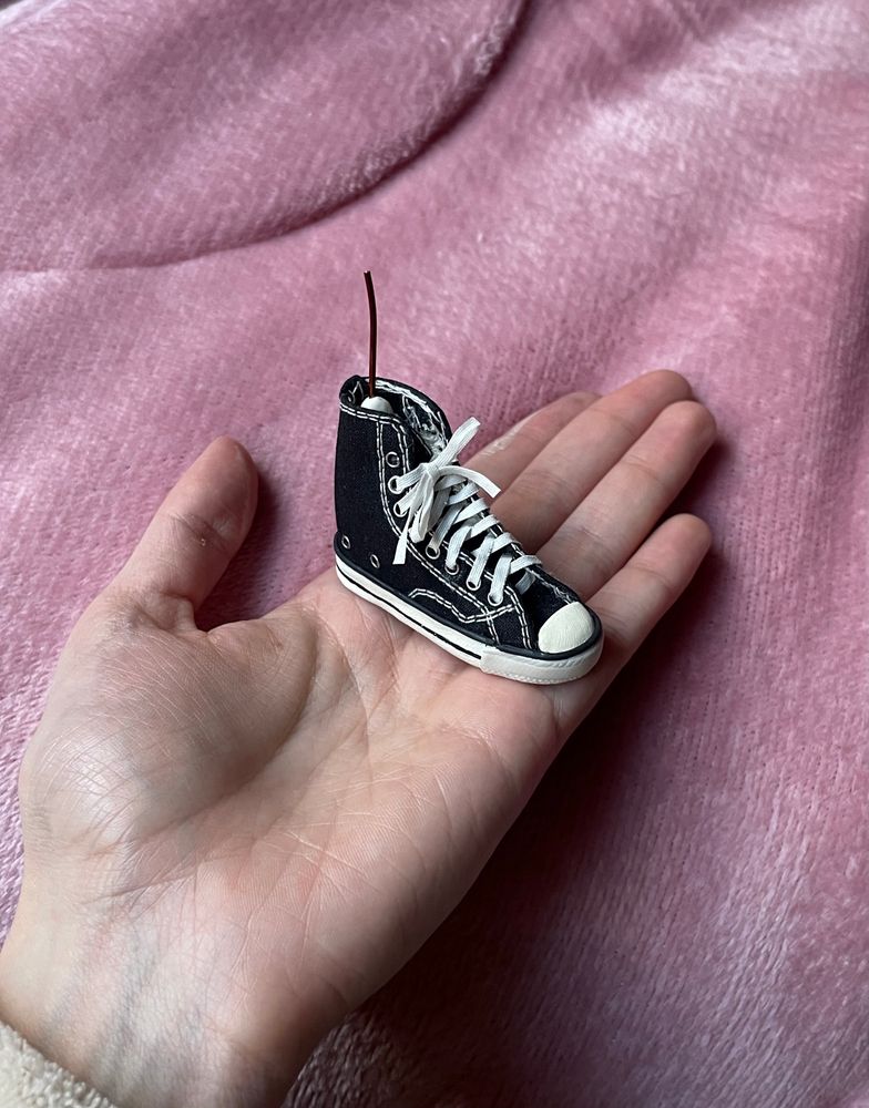 Na foto estou segurando um mini tênis all star preto que eu mesma fiz, em miniatura.