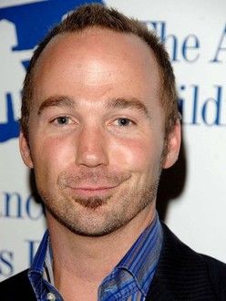 A photo of screenwriter Jake Wade Wall smirking smugly.