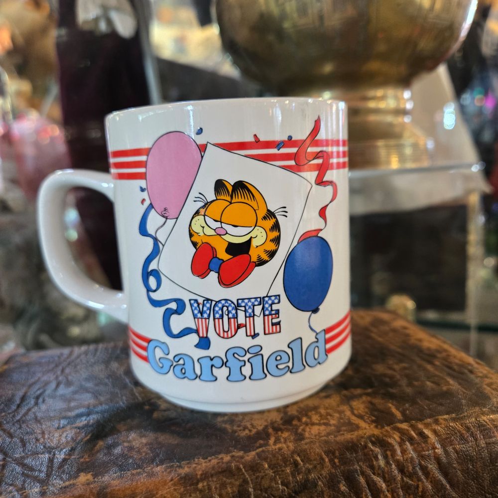 A 1980s Garfield the cat mug that says "VOTE Garfield."