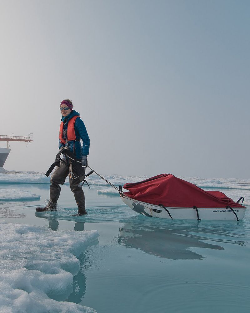 A researcher (Madison Smith) walking on sea ice covered by melt ponds. Photo by Evgenii Salganik.