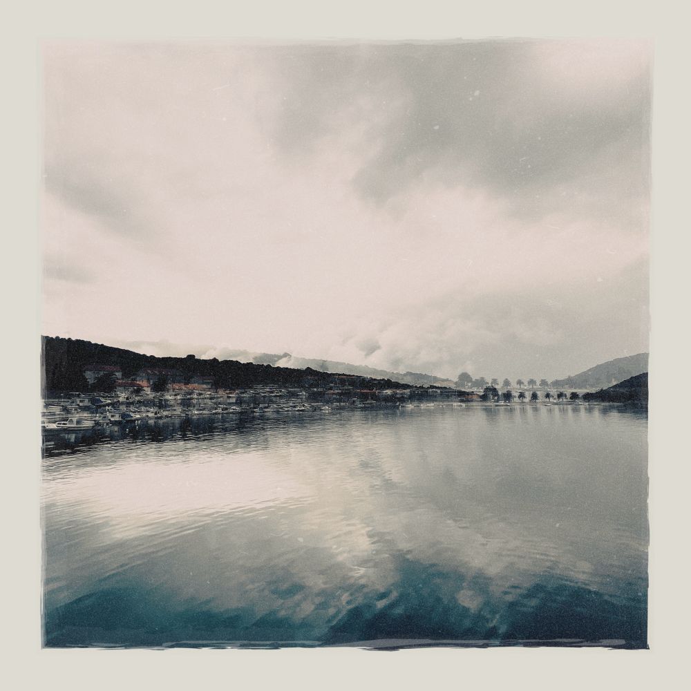 A double exposure photo of sea and sky, with a bit of land in the middle