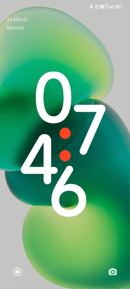 A green wavy wallpaper with the time 07:46 shown in the middle with two red dots dividing the hours and minutes