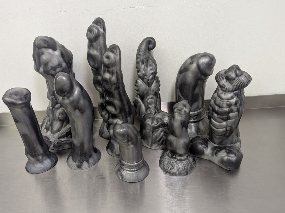 A batch of ten dildos with mottled silver over black and holographic rainbow shimmer 