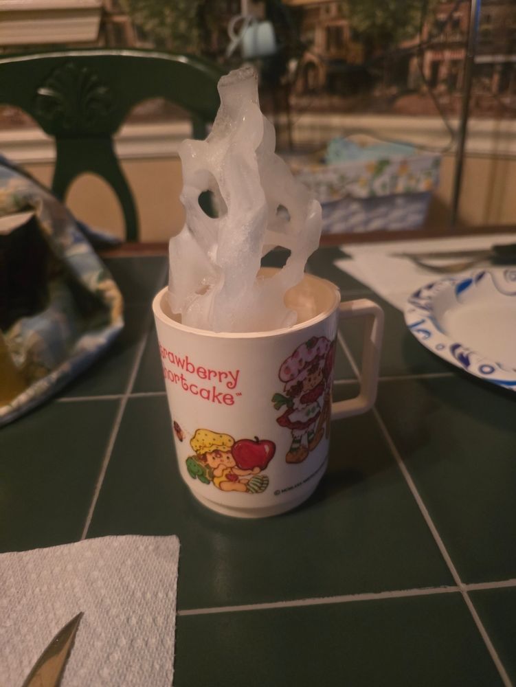 Cup with a giant block of ice sticking out of it.