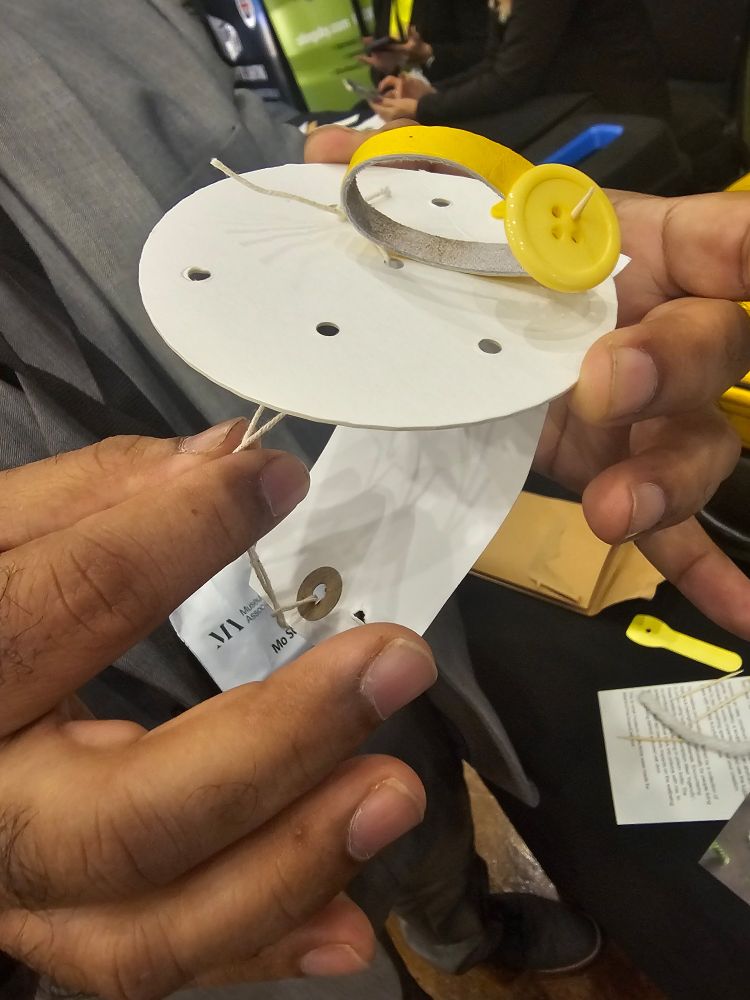 Hands making a sculptural object from simple white  and yellow materials  