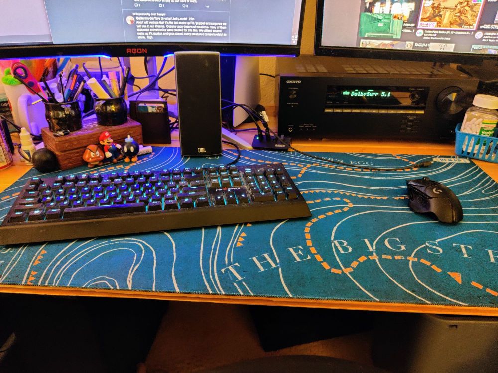 Huge teal green Remap Radio desk mat in place, dwarfing the full sized mechanical keyboard and mouse placed atop the relief map design.