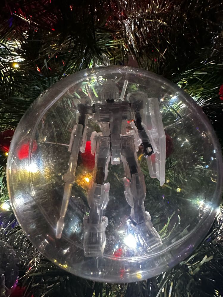 Close up of a Christmas tree including an ornament that is a clear-armoured RX-78-3 G3 inside of a clear bubble. 